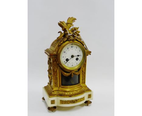French ormolu and white marble mantle clock, the arched top surmounted by garlands and foliage over an enameled dial with Ara