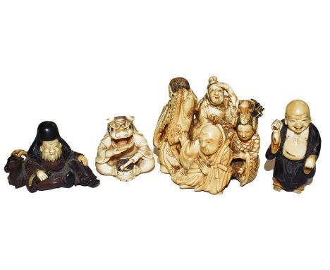 A Japanese Meiji period ivory netsuke in the form of a group of figures, another of a drummer in a ceremonial mask, and two o