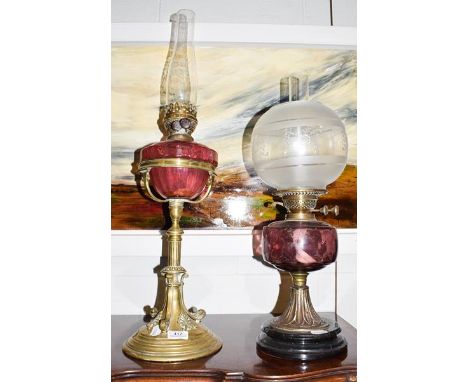 A Victorian brass based oil lamp with cranberry glass reservoir, raised on a stepped circular plinth adorned with anthemion, 