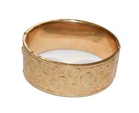 A 9 carat gold hinged bangle, inner measurements 6.0cm by 5.3cm .  Gross weight 36.4 grams. 