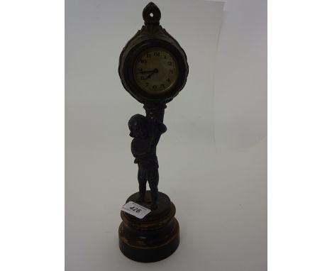 METAL MANTLE CLOCK ON WOODEN BASE DEPICTING BOY HOLDING HORN 32CM TALL