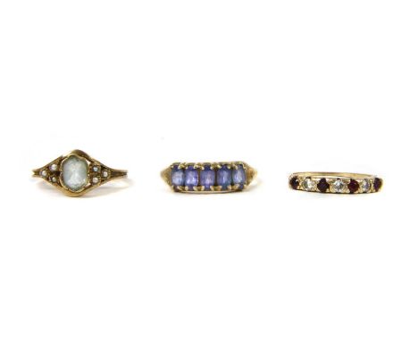 A 9ct gold tanzanite ring, with a row of oval mixed cut tanzanites, claw set to tapered shoulders and a plain shank, Birmingh