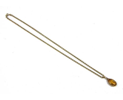 A 9ct gold citrine pendant, a pear cut citrine claw set to a plain frame, with fluted bale, suspended from a trace link chain
