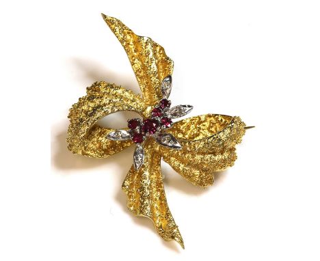 An 18ct gold two colour ruby and diamond bow brooch, c.1950, a central spray cluster with graduated circular mixed cut rubies