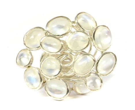 A silver moonstone cluster ring, oval cabochon moonstones rub set to plain collets, with wire gallery and seven row wire shan