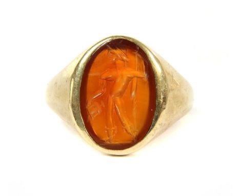 A gold oval cornelian signet ring, the cornelian with intaglio carved figure rub set to tapering shoulders and a plain D sect