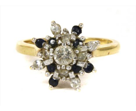 An 18ct gold diamond and sapphire cluster ring, a brilliant cut diamond, claw set to the centre, to two tier surround of alte