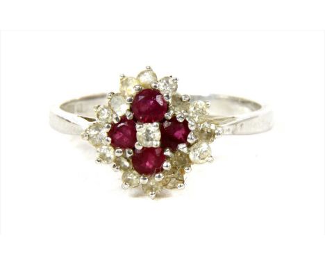 An 18ct white gold diamond and ruby cluster ring, a brilliant cut diamond with a quatrefoil surround of circular mixed cut ru