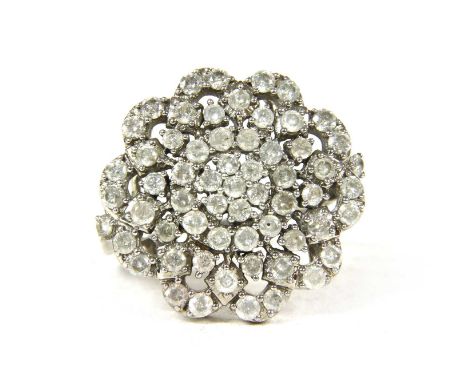 A silver diamond cluster ring, with brilliant cut diamonds, claw set to an openwork flowerhead cluster, with trifurcated shou