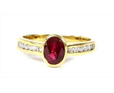 An 18ct gold ruby and diamond ring, an oval mixed cut ruby, rub set, to a row of brilliant cut diamonds, channel set to the p