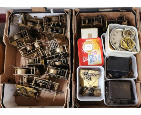 A box containing twelve brass clock movements and a box containing mantel clock and carriage clock movements and clock parts 