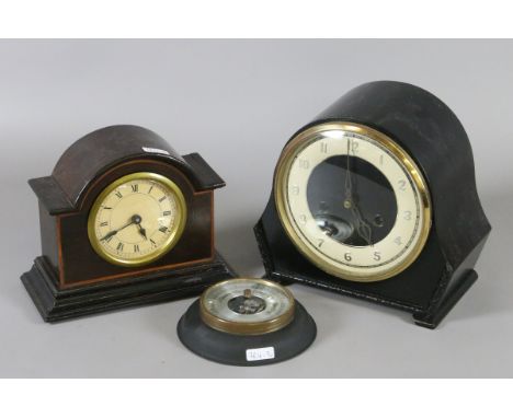 Two mantel clocks, one chiming on a gong, along with a barometer.