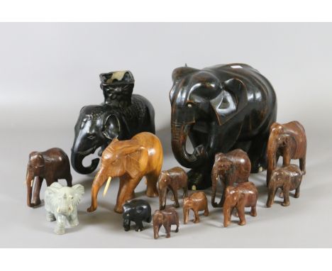 A collection of carved hardwood elephants and two ceramic examples.
