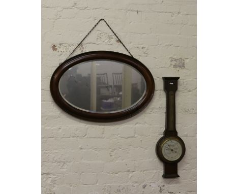 An oval mahogany bevel edge wall mirror and  oak cased anaroid barometer (AF).