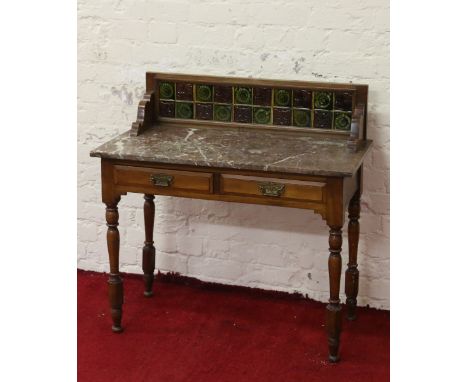 A Victorian walnut marble top washstand with tiled back raised on trunk supports.