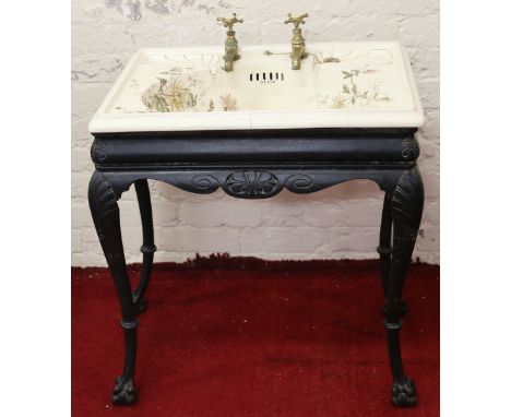 A Victorian Delta ornate cast iron based wash stand raised on ball and claw supports and set with ceramic sink decorated with