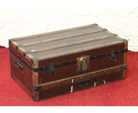 An antique wooden bound travel trunk with carrying handles.