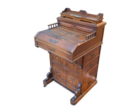 Victorian carved walnut Davenport having elevating stationery compartment, slide our easel writing surface and four side draw