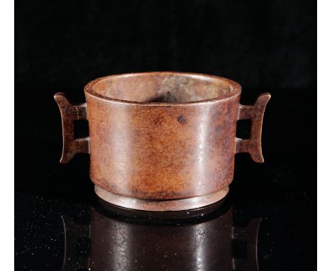 A CHINESE BRONZE VESSELbearing an impressed mark to the base, of archaic form, with two pierced handles, 8cm high x 16cm wide