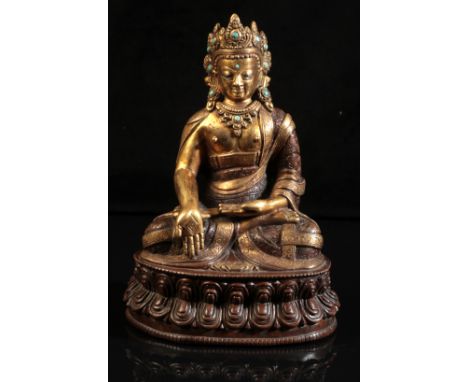 A GILT BRONZE FIGURE OF SEATED BUDDHAprobably 18th century or after, modelled in padmasana on a double lotus base, the right 