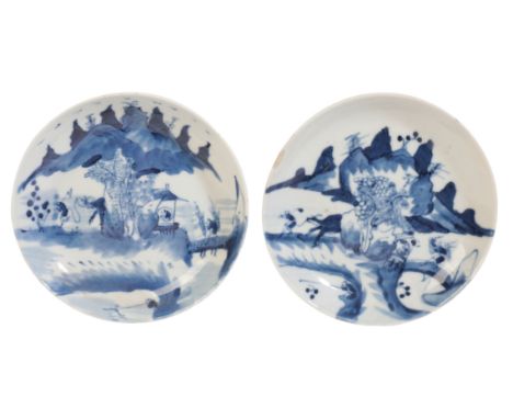 A PAIR OF CHINESE PORCELAIN BLUE AND WHITE SAUCERS Qing dynasty, both decorated with figures and pagodas to the centre and mo