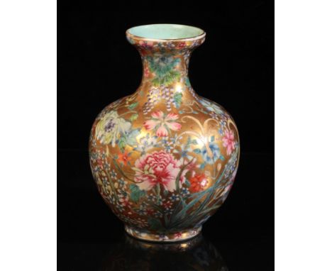 A CHINESE PORCELAIN 'HUNDRED FLOWERS' FAMILLE ROSE VASE bearing a six character Qianlong seal mark to the base, the gilt grou