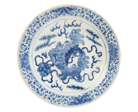 A CHINESE PORCELAIN BLUE AND WHITE 'BUDDHIST LIONS' DISH Qing dynasty, decorated with two lions within a floral border, 30.5c