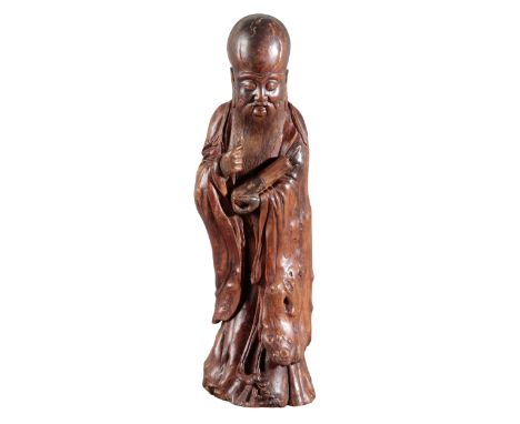 A CHINESE CARVED ROOTWOOD FIGURE OF SHOULAO possibly Ming dynasty, figured holding a scroll in his left hand, a large cavity 