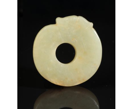 A CHINESE 'DRAGON' JADE possibly Shang or Western Zhou period, carved in ring form, the dragons head eating its tail, with in
