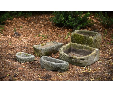 A GROUP OF FIVE VARIOUS CARVED STONE TROUGHS OR BASINSOf varying formsThe largest trough 42cm high, 59cm wide, 37cm deepThe l