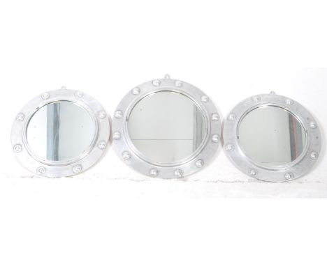 Three late 20th century vintage style porthole mirrors in silver colourway. Circular form with large studs surrounding the fr