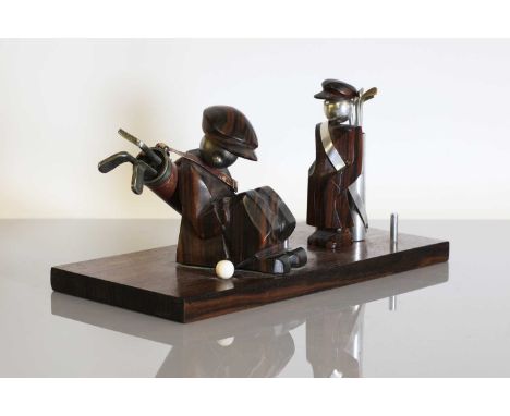 An Art Deco rosewood and chrome desk stand, modelled as a golf caddy, seated beside an ivory ball, with three prongs to the s