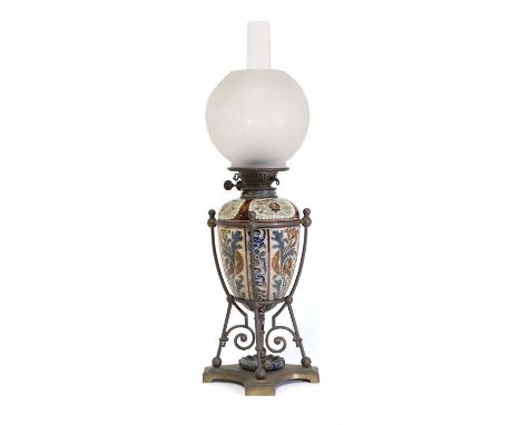 A Doulton Lambeth stoneware oil lamp,by Mark V Marshall, the incised and cut, low relief panels cradled in a metal stand, the