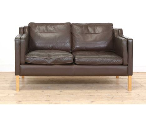 A Stouby brown leather two-seater settee,raised on birch supports, 141cm wide 83cm deep73cm high, seat 43cm highBuying this s