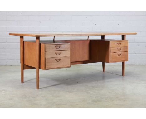 A Danish teak desk, designed by Kai Kristiansen, with a floating top, with three drawers either side, the back mounted with a