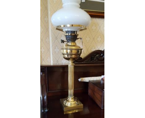 A Brass Oil Lamp Standing on a Reeded Corinthian Column with square base, chimney & glass shade.