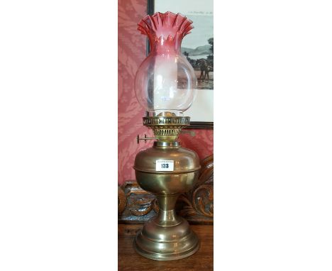 A Victorian Brass Oil Lamp having a Clear to Cranberry Shade.