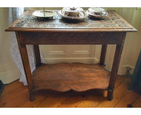 A Well Carved 19th Century Oak Side Table, having a carved top and freeze standing on square carved supports with a shaped lo