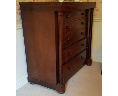 A Georgian Mahogany Scotch Chest of Drawers, having two short over four long graduated drawers flanked by a pair of turned ta
