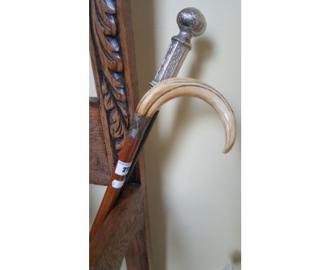 A Silver and Tusk Mounted Walking Cane, and another walking stick (2).