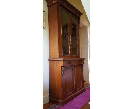 A Victorian Mahogany Bookcase of Neat Proportions having a pair of glazed panel doors above a single long drawer and cupboard