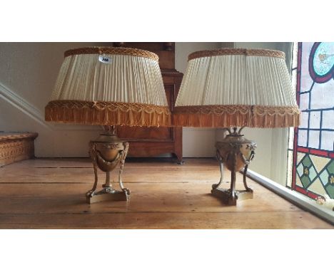 A Pair of French Empire Style Gilt Metal Lamp Bases with cream pleated silk shades.