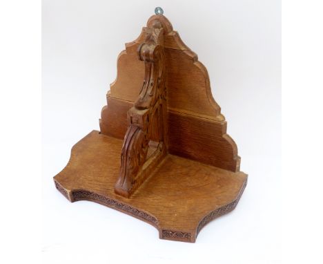 A Victorian oak clock bracket, circa 1870, of shaped outline with outset corners, flowerhead filled guilloche frieze, on a le