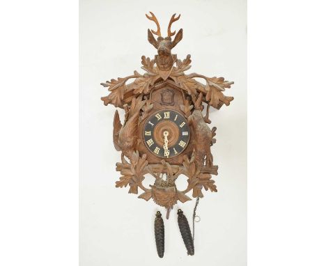 20th century cuckoo clock with carved stag's head surmount over rabbit or hare and bird, the chalet case additionally applied
