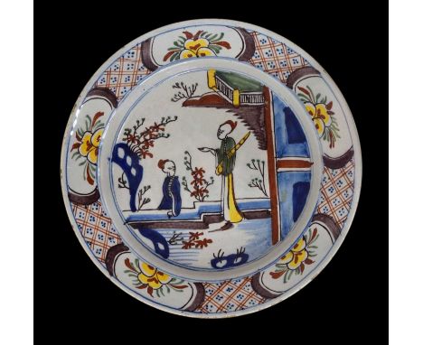 Mid 18th century delftware dish, probably Bristol, painted in polychrome enamels in the chinoiserie taste with figures in a g