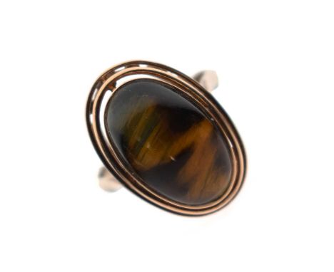 Tigers eye ring, the oval cabochon rubover set, the yellow metal shank stamped '9ct', size O, 4.1g gross approx