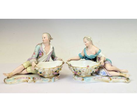 Pair of Meissen porcelain figural sweetmeat dishes, late 19th or early 20th century, modelled as 18th century style gallant a