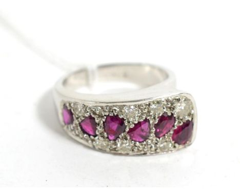 A 9 carat white gold ruby and diamond ring, a tapering plaque pavé set with pear cut rubies and round brilliant cut diamonds,