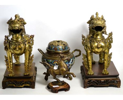 A pair of gilt bronze Buddhistic lions on hardwood stands, a cloisonne censer (a.f.) and a bronze model of one of the eight h
