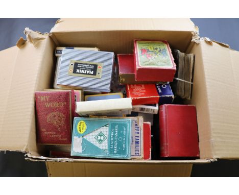 Multiple packs of playing cards, two glass apothecary bottles and monopoly